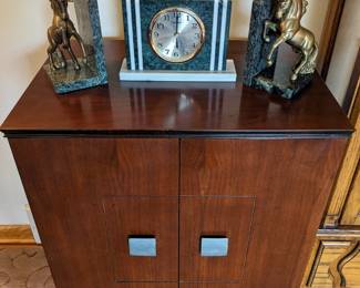 Record cabinet with unicorn bookends and marble clock.