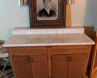 This counter and cabinet is narrower on the bottom giving it that MCM look and is on wheels. Marked Marsh Orleans Maple.