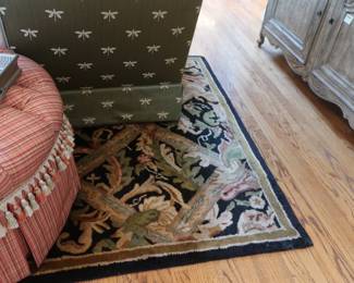 Red  plaid  hassock.     Black  edge   leaf  pattern  wool  rug.  It  is  5'  x  8'