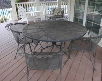 Woodard patio table  and  four  chairs.  It  is  53  1/2".         