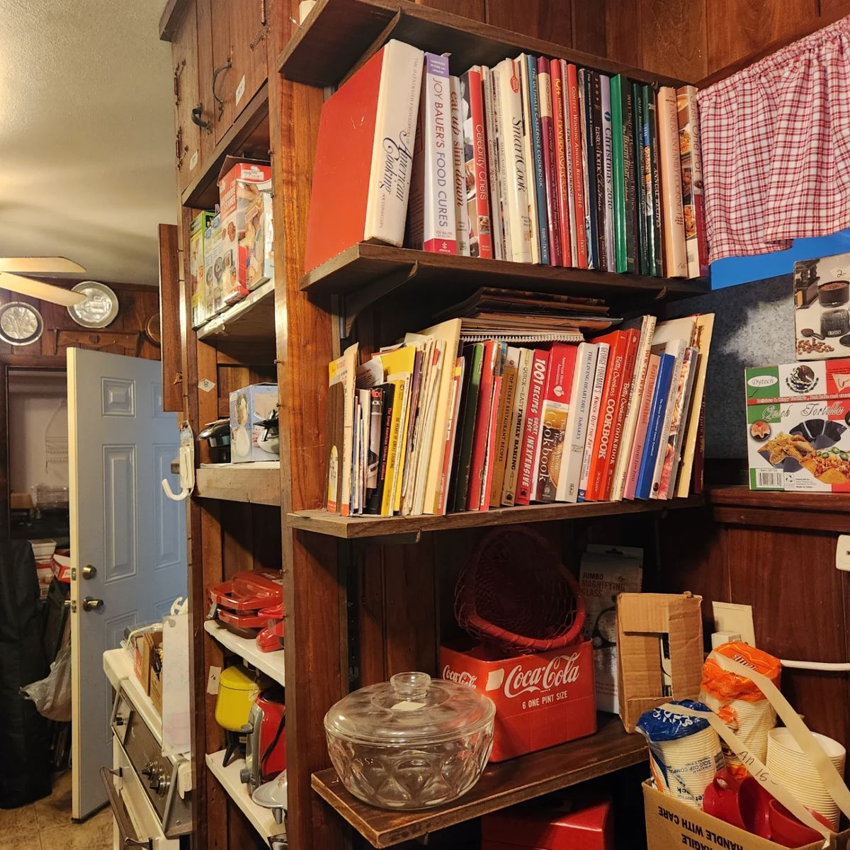 This is part of kitchen area - lots of cookbooks & collectibles, Coca-Cola container