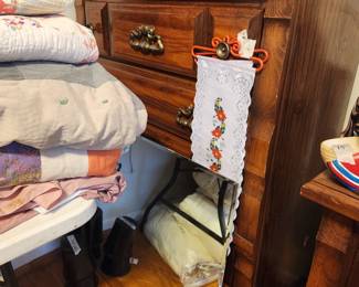 Chest in corner of room with quilts & various sizes of sheets, etc 