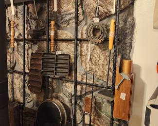 Cast iron items & more on wall in living room behind stove 