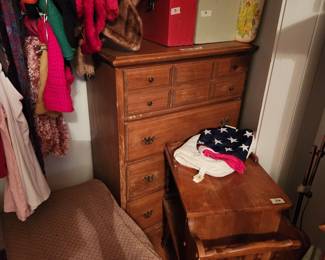 Another chest in closet with small table in front 
