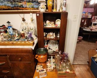 Chest to left in picture with decor on top, cabinet with collectibles behind coffee table