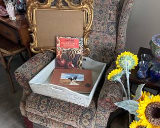 Recliner, gold scrolled frame, wooden trays, books
