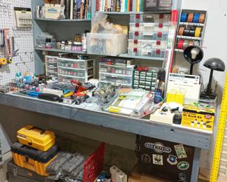Workbench full of paints and parts and manuals