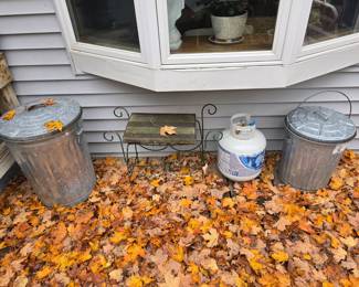 2 galvanized covered trash cans.  Propane tank goes with the grill, cute little side table or stool.  How about those autumn leaves!!! The real thing too!