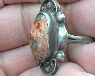 Boulder Opal? Agate imbedded in red jasper… not sure, but it’s housed in silver and very unique in it’s beauty!