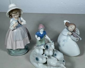 (3pc) LLADRO & OTHER FIGURINES | Including: Nao by Lladro figurine of girl with flowers, lladro figurine of girl playing violin, and German porcelain girl with geese figurines. - h. 8 x w. 4 x l. 4 in (largest)
