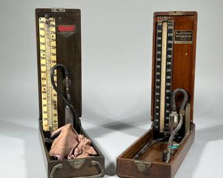 (2pc) EARLY BAUMANOMETERS BLOOD PRESSURE MEDICAL DEVICES | Two "Baumanometer" tabletop blood pressure checkers in fitted wood boxes, each with enameled plaque inside the lid. - w. 4.75 x l. 14.5 in (larger case)