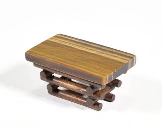 MINIATURE TIGER'S EYE TABLE | Dollhouse miniature tigers eye top low table on a stacked log base; no apparent signature. - h. 1-1/8 x w. 1-1/2 x l. 2-3/8 in
