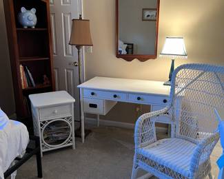 Reeded desk, wicker rocker, wicker side table, bookshelf, lamps, mirror