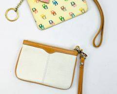 Two Dooney & Bourke Wristlets. One Is White Leather With A Tan Wrist Strap. The Second Is A Multicolored Coated Canvas With A Pink Heart Logo Charm And A Tan Wrist Strap.
