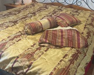 gold and burgundy comforter and accent pillows