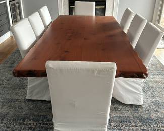Custom hand-crafted live-edge Woodland Creek dining table; 8 Crate and Barrel white slip-covered dining chairs