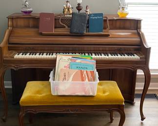 Piano with bench, sheet music, vintage hymnals, oil lamps 