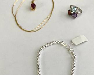 Ruby and diamond necklace, sterling silver beaded bracelet
Garnet, blue topaz, amethyst and white sapphire ring. 