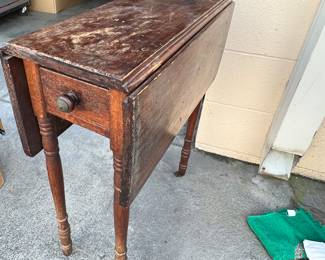 A small antique table with fold down leaves, great for sewing room or hobbiest.. Just needs a little love.