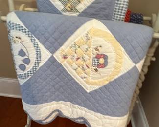 Pair of twin size quilts on rack