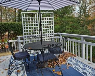 Beautiful outdoor patio set of table and five chairs, umbrella, and outdoor rug.