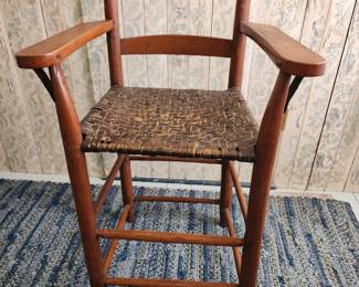 Shaker style high chair with basket weave seat.