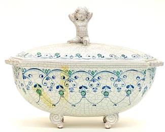 Lot # 59	$100.00	VAL DEMONE, SANTO STEFANO VINTAGE ITALIAN FOOTED TUREEN AND WINGED PUTTO HANDLE 	Height 11 in, width 14 in, depth 9 in. Antique lidded ceramic tureen with hand painted floral and abstract design on notable crackalure glazing. Angled round scrolling feet and ornamental rim from the Santo Stefano region of Italy.  Lid has a prominent seated putto handle with wings.	Bid at Woodardlipe.com or call 314-899-0098 for more information.