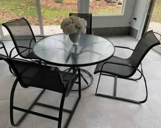 Glass topped round table with black metal base - excellent condition and shown with 4 black metal and black mesh armchairs (8 available)