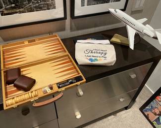 Another view of the 4-drawer file cabinet/dresser with stainless front and pulls shown with backgammon set, travel bags and model plane