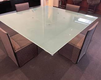 Glass and steel dining table by Lella and Massimo Vignelli: 4 pedestals steel and glass top: 72" square x 1" , shown with dining chairs: custom upholstered parsons chairs with leather trim and down seat cushions (8)
