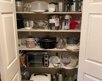 The kitchen pantry is full of kitchenware and kitchen appliances, as well as cookware and storage containers.