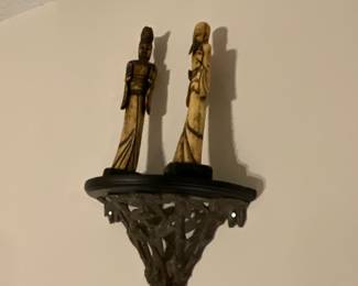 Figurines on ornate sconce