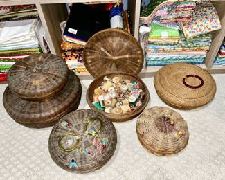 Several antique woven sewing baskets, wooden spools