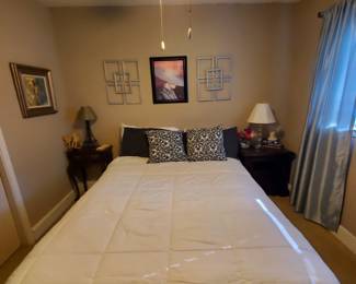 Queen size bed frame and mattress, side tables and lamps.