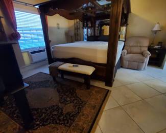 Beautiful Large Vintage 1970s California King Canopy waterbed with mattress. Solid wood with 6 sliding drawers in base.  Matching bedside tables.  3 of 5 piece full set.  Oriental black and tan area rug. table lamps. Tan lazy boy electric lift char recliner.