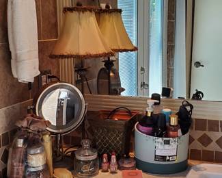 Conair Reflections double-sided incandescent lighted vanity makeup mirror 1x/7x magnification. Assorted nail polish, and hair care set including flat iron, Exotic candlestick table lamp and various personal are assundries.