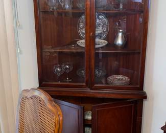 Wood corner cupboard with glass front doors and lower storage