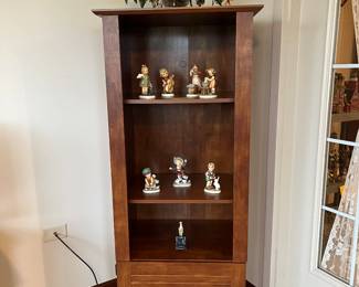 A few Hummels, narrow cabinet
