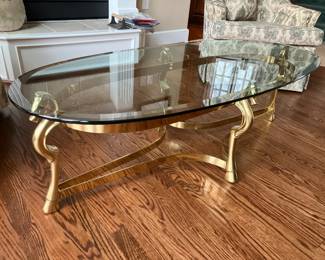 Brass and glass oval coffee table, horsehead detail
