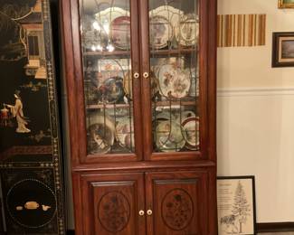 Cabinet with carved wood, several collectible plates, Russian, Norman Rockwell. Two musical boxes. 