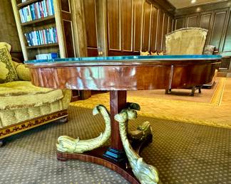 Continental Neo-classical mahogany center table with carved gilt wood dolphin supports.  Circa 1830