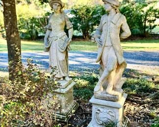 Colonial man and woman concrete statues on pedestal 