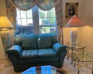 LEATHER LOVESEATS, BRASS AND GLASS TOP TABLES AND DECORATOR LAMPS