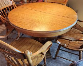 Round Pedestal Table with 2 Leafs and 4 Captain's Chairs. 