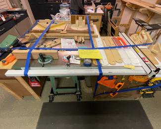 General International table saw, installed in a cabinet & includes many accessories