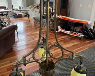 Antique three-arm brass chandelier with art glass shades.