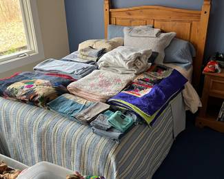 Full-size pine bed with mattress and box spring.