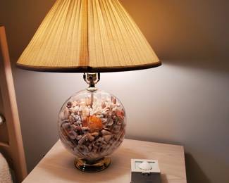 Sea shell filled lamp has a seahorse in it