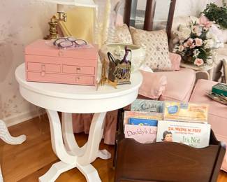 Gold trunk, trays, shabby chic pink chair and ottoman, white side table, kids books, pillows, wicker coat stand, Kate Spade handbag, Hollywood Regency decor
