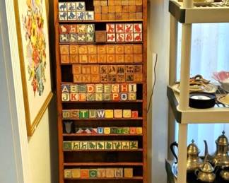 Old vintage children's wood ABC Blocks of different makers, some have Disney characters on them, all in a old handmade tall wood display rack.